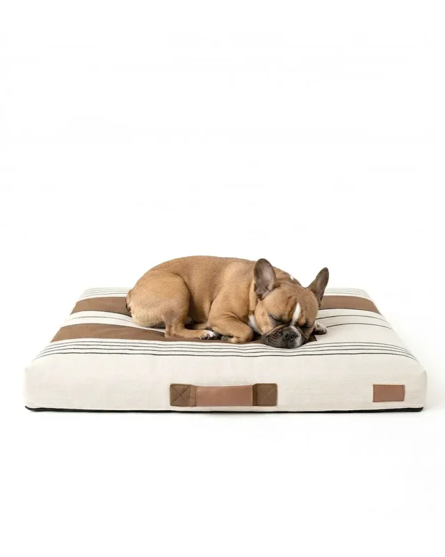 Frenchie sleeps on the NapMat Basque French Bulldog Bed in beige color