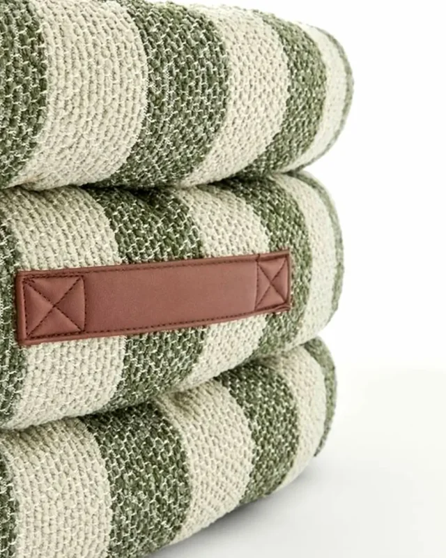 Sage Stripe Frenchie Designer Sofa Bed fabric detail — woven bouclé in sage green and natural cream with a horizontal saddle leather pull tab and reinforced cross-stitch corners.