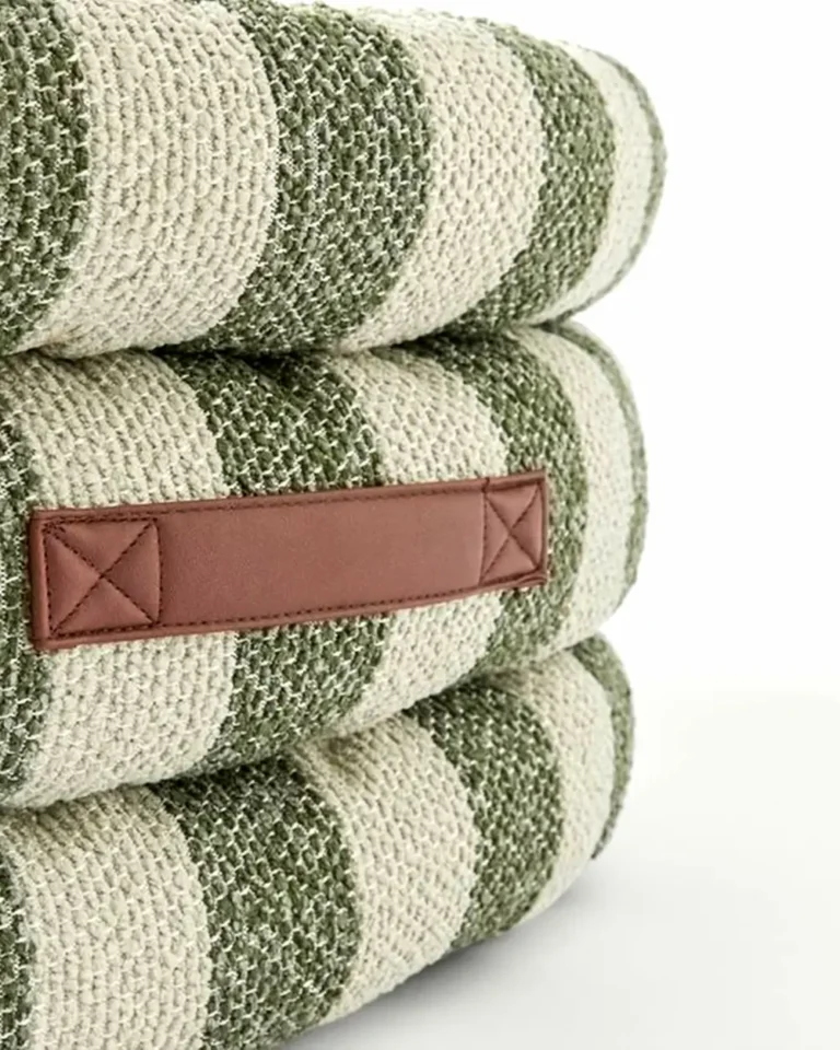 Sage Stripe Frenchie Designer Sofa Bed fabric detail — woven bouclé in sage green and natural cream with a horizontal saddle leather pull tab and reinforced cross-stitch corners.